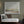 Harmony's Promise limited edition landscape paper print in white frame on sage green wall above rattan daybed – abstract landscape wall art DT Art Studio.