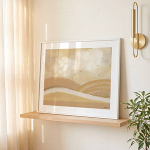 Over The Hills limited edition landscape paper print in white frame on timber shelf – abstract golden hills wall art DT Art Studio.