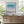 Coastal Azure limited edition paper print in black frame above timber sideboard – abstract seascape wall art DT Art Studio.