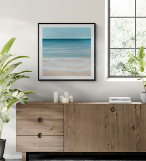 Coastal Azure limited edition paper print in black frame above timber sideboard – abstract seascape wall art DT Art Studio.