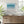 Coastal Azure limited edition paper print in white frame above timber sideboard – abstract seascape wall art DT Art Studio.