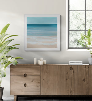 Coastal Azure limited edition paper print in white frame above timber sideboard – abstract seascape wall art DT Art Studio.