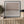 Dusk limited edition paper print in black frame above slatted timber sideboard with olive tree – abstract coastal wall art DT Art Studio.