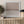Dusk limited edition paper print in white frame above slatted timber sideboard with olive tree – abstract coastal wall art DT Art Studio.